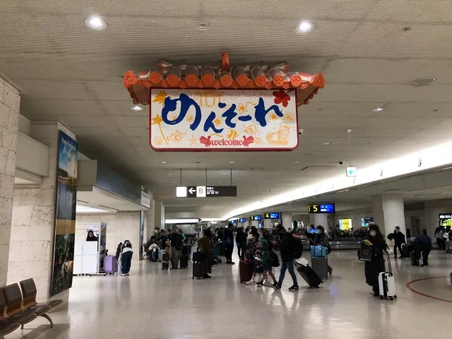 Welcome sign reading "Mensore" in Naha Airport's arrival lobby